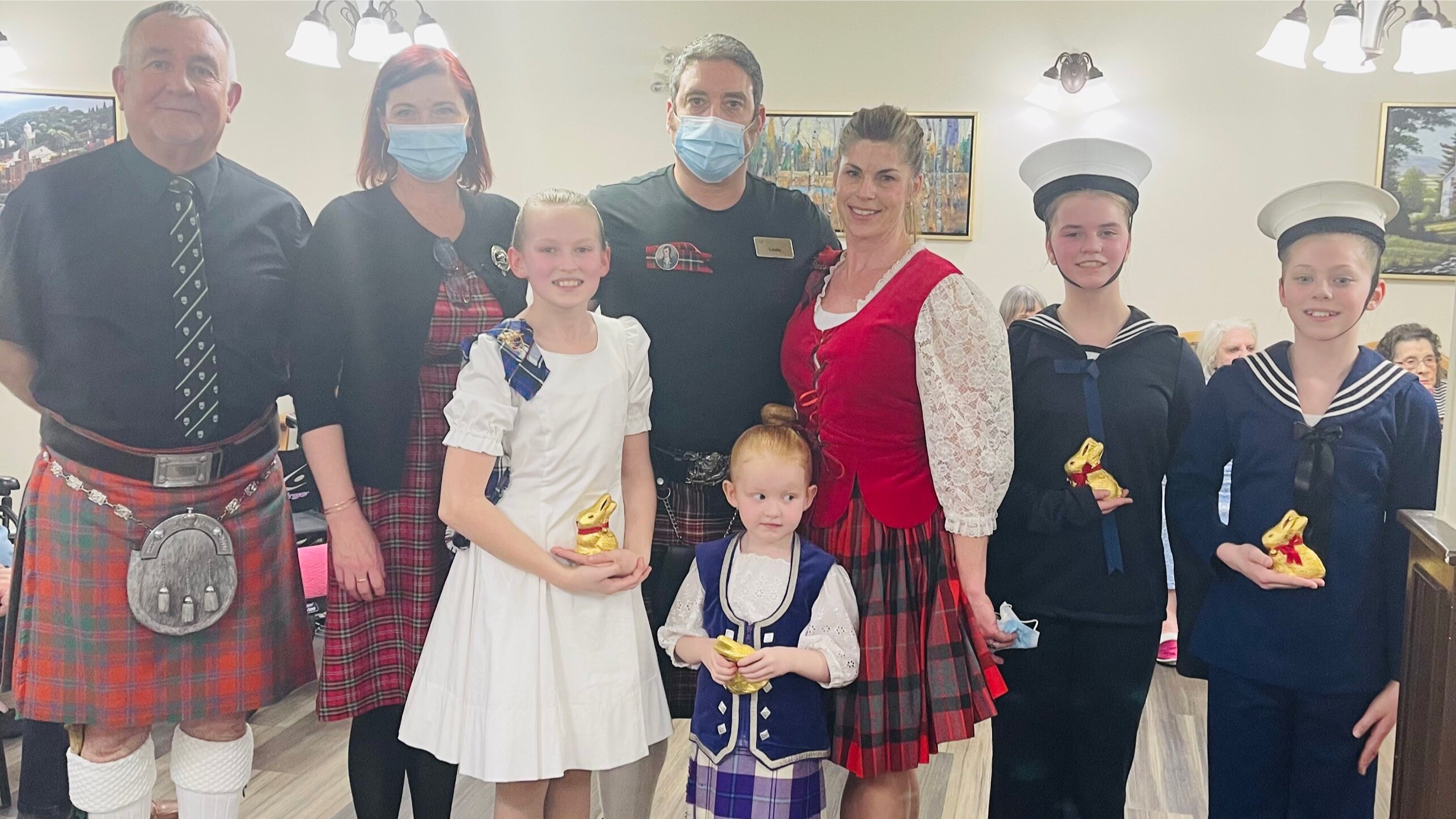 A picture of a family in Scottish outfits in a retirement home