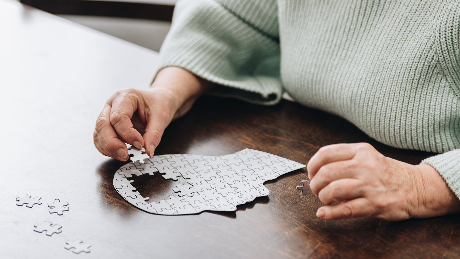 An elderly person solving a puzzle while attending Online Webinar in senior living