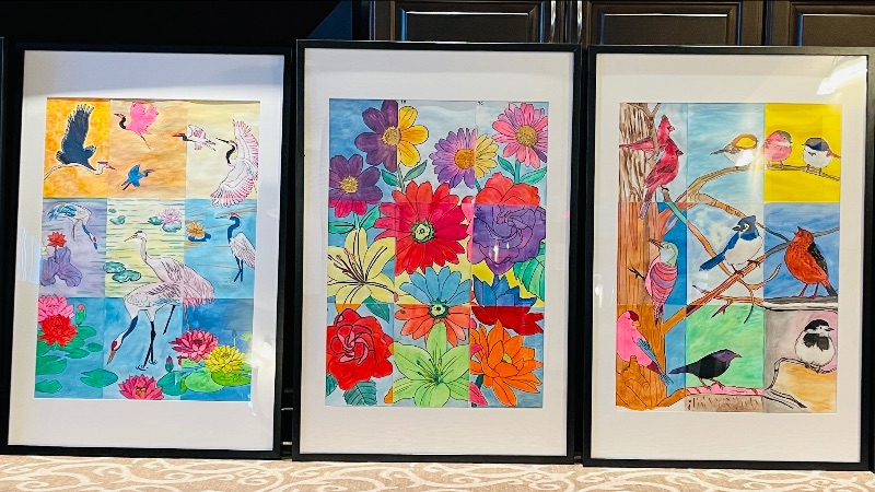 A picture of 3 colourful paintings of birds and flowers in a senior living community