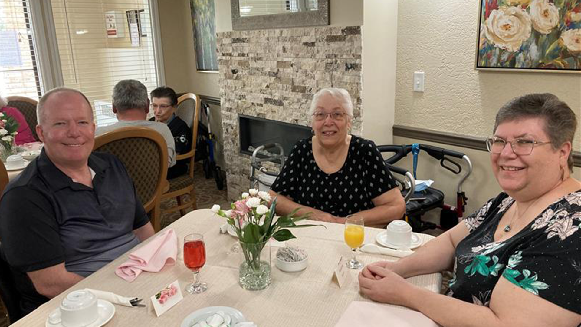 A senior woman sitting with two adult children