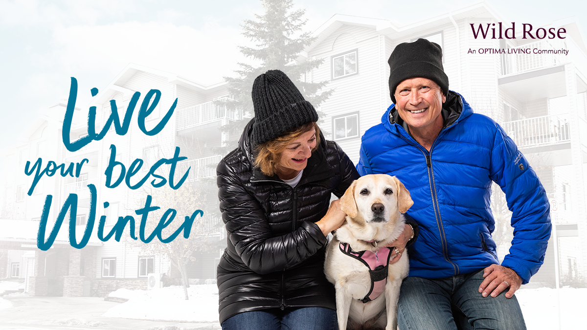 Live your best winter text next to two seniors smiling with their dog between them outside senior living.
