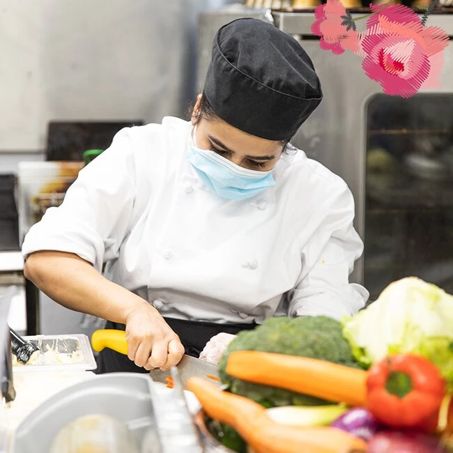A lady chef cutting vegetables and preparing healthy meals for seniors