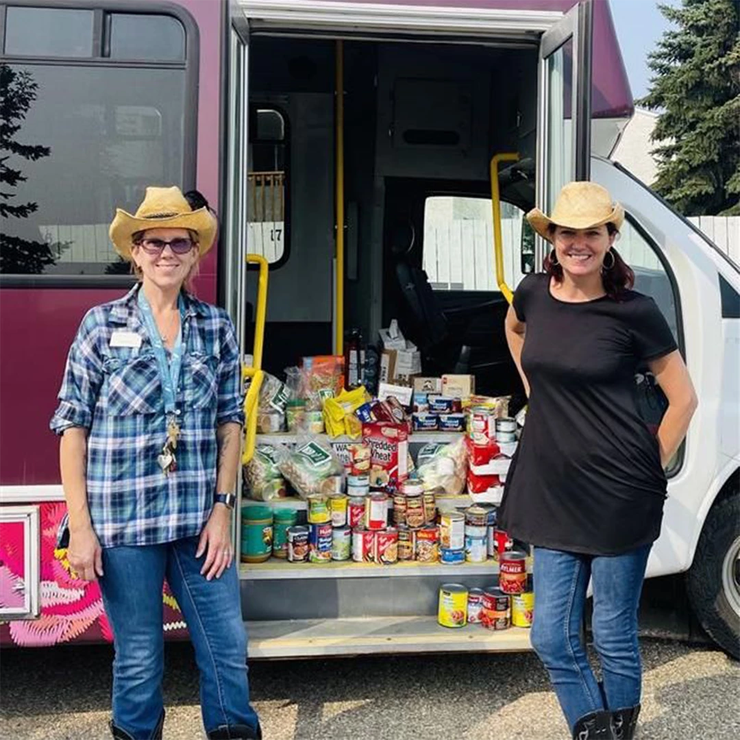 Food bank donations on the Wild Rose bus with two staff members in front