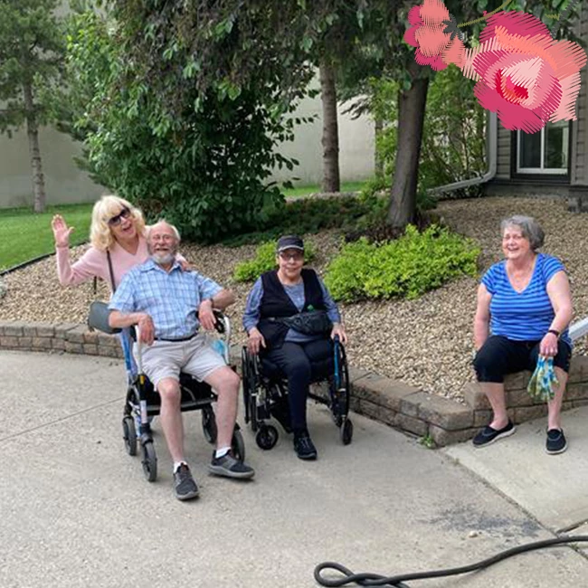 Some elderly people sitting in garden and smiling outside Wild Rose senior living community