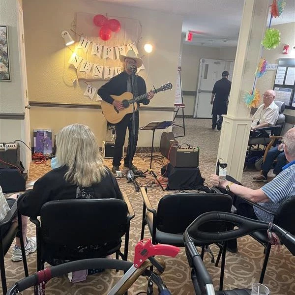 Seniors enjoying a performance by an acoustic musician.