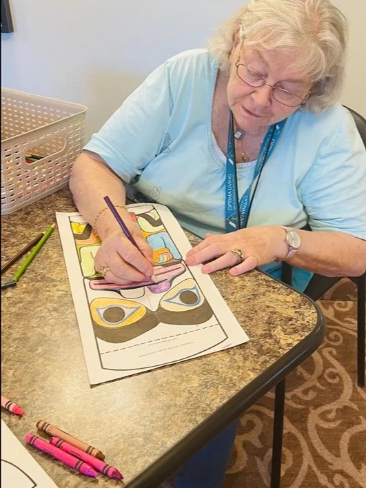 Senior living resident finishing her colouring page for Truth and Reconciliation Day.