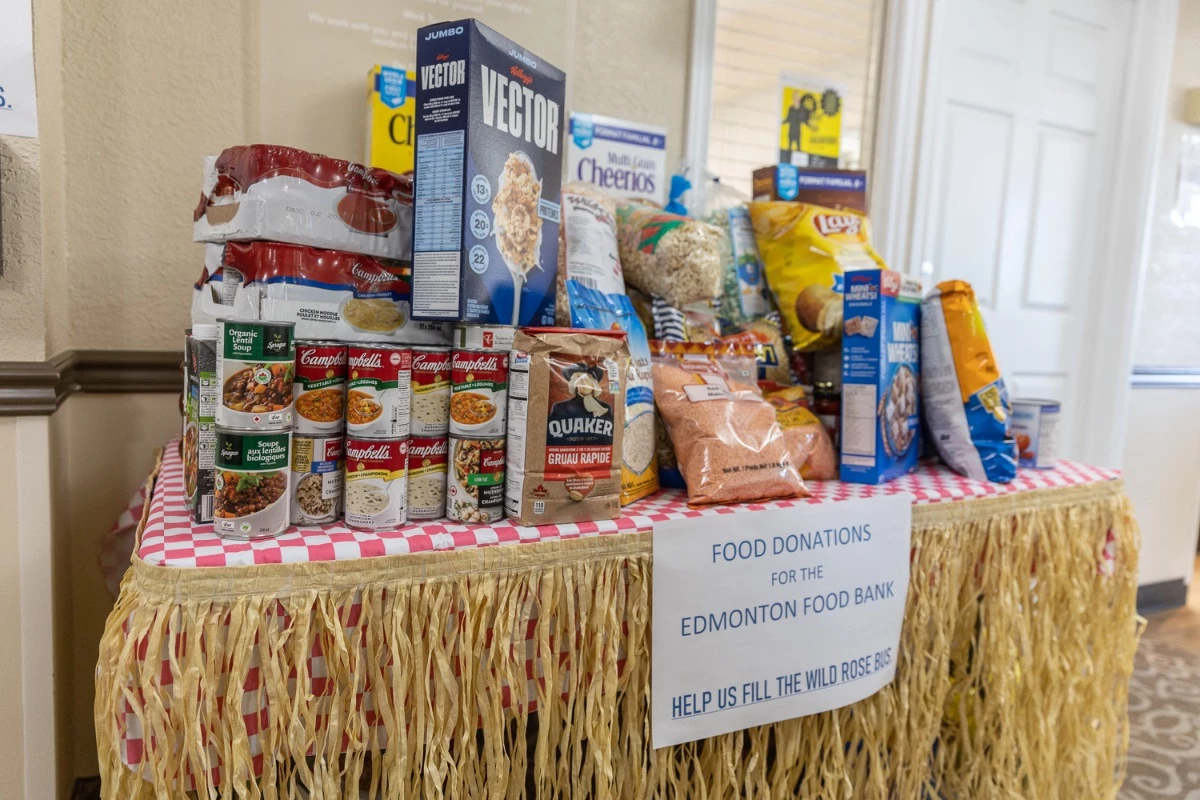 Food Bank donations on a table. Cereal, soup, and other food all stacked on top of each other.