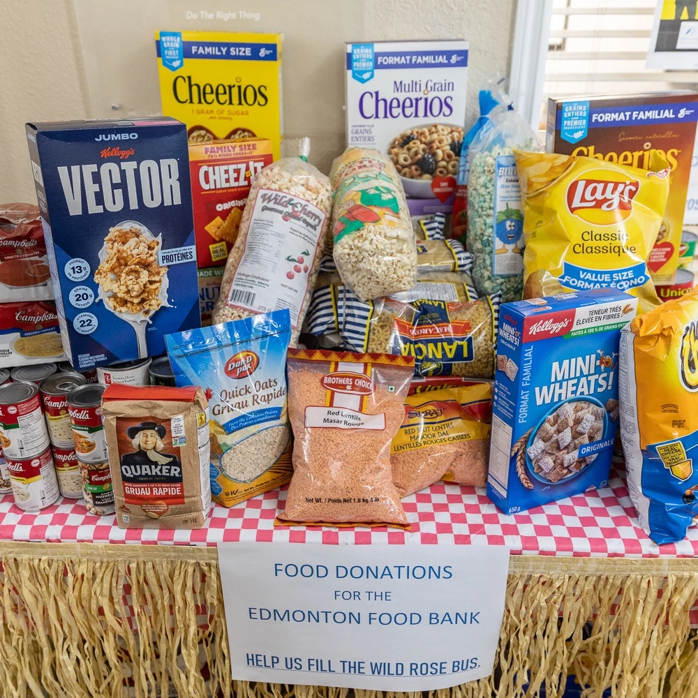 A table full of food bank donations, both canned and boxed donated by Wild Rose Senior living community