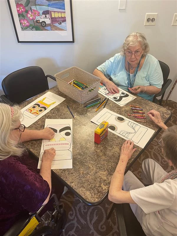 Senior living residents colouring pages together for Truth and Reconciliation Day.