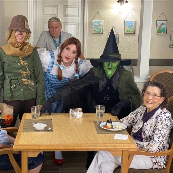 Wizard of Oz characters posing in front of senior living residents while they're eating.