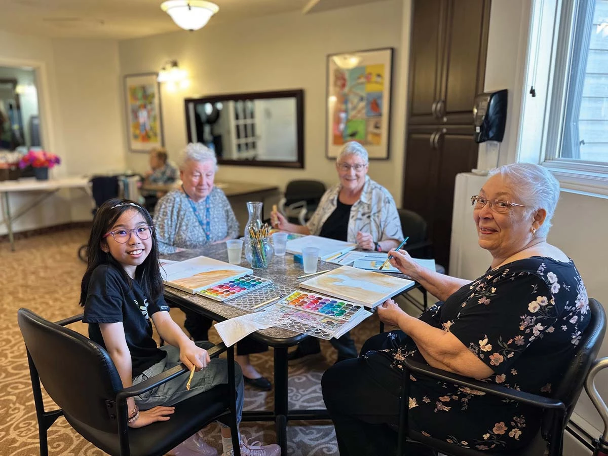 Senior women painting with a little girl